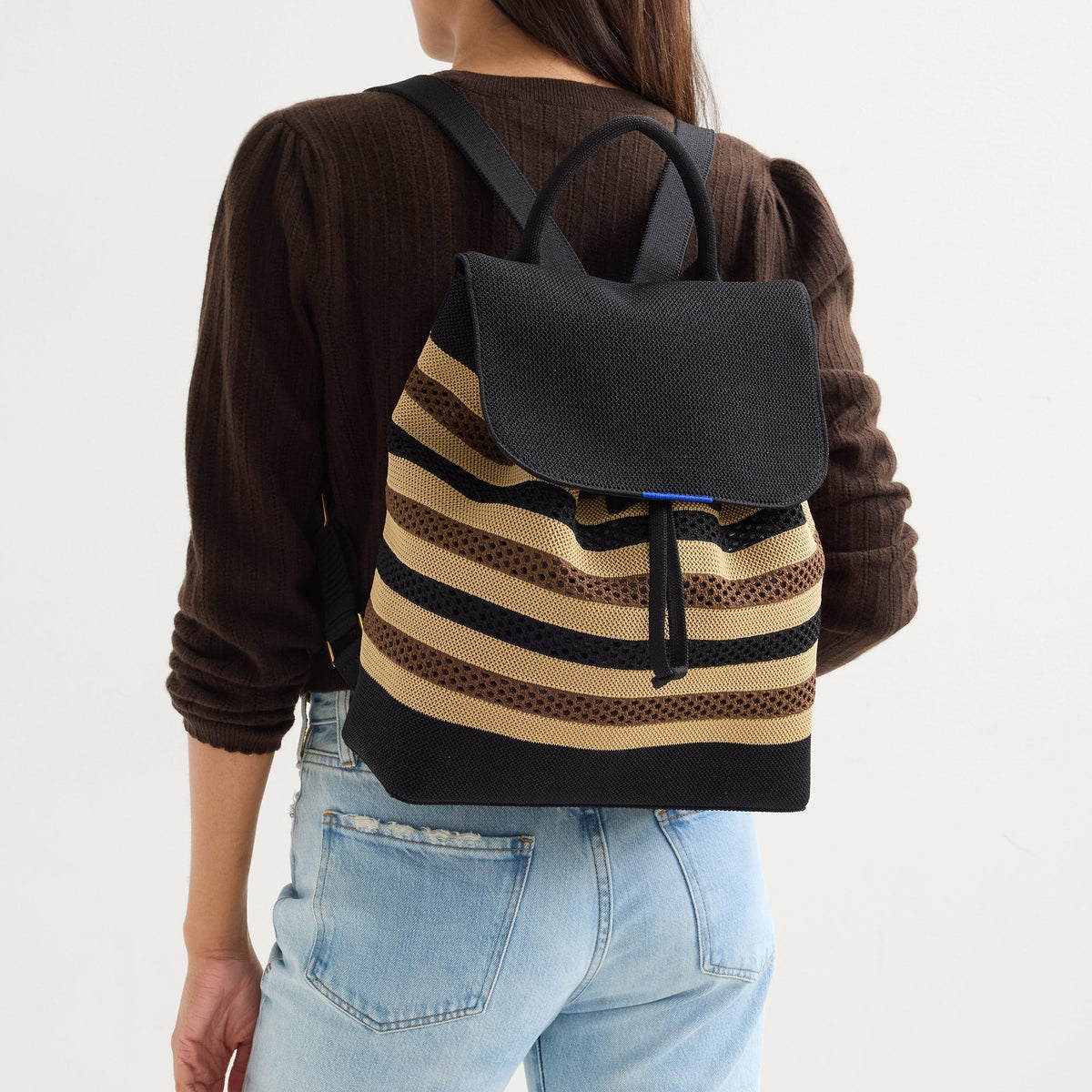 hover | Model wearing The Cinch Backpack in Mocha Stripe.