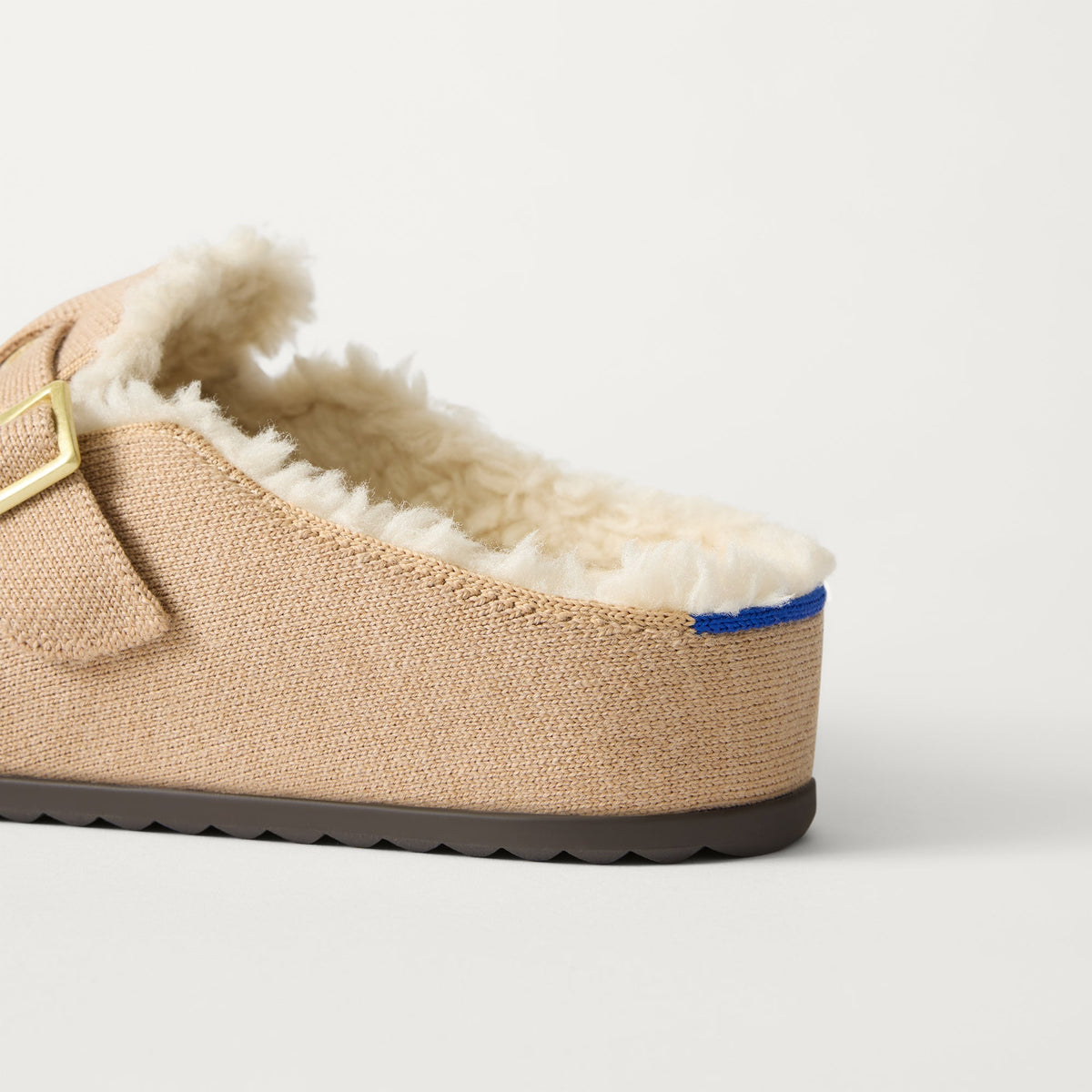 Close up of the heel of The Teddy Buckle Clog in Honey, with Rothy's signature blue halo.